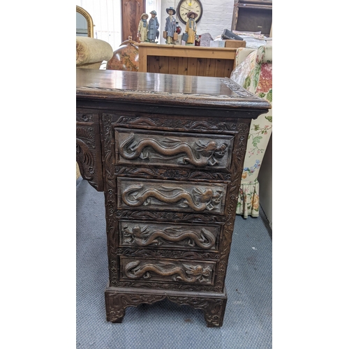 83 - An early 20th century Chinese export padouk wood twin pedestal desk, relief carved decorated with dr... 