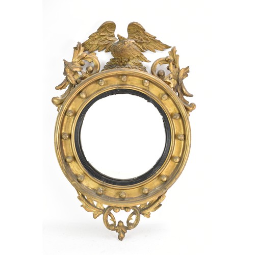 142 - A Regency wall mirror, having a convex plate in a gilt moulded and carved giltwood frame with a ball... 