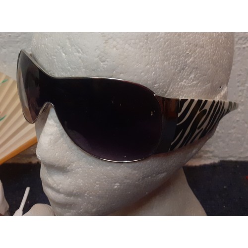 107 - A mixed lot comprising fashion sunglasses to include Wayfarer style glasses, a pair of white Nike Ai... 