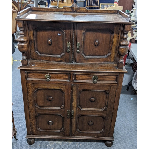 223 - An early 20th century oak court cupboard having four panelled doors and two frieze drawers, 132cm h ... 