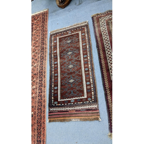 230 - Three hand woven rugs to include an Afghanistan small rug, 117cm x 55cm, a Balouch design rug, 138cm... 