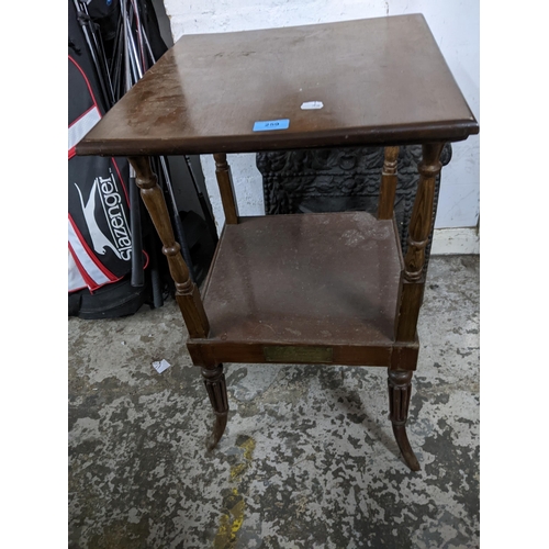 259 - A Regency mahogany two tier table standing on turned, fluted and splayed legs, the under tier with i... 