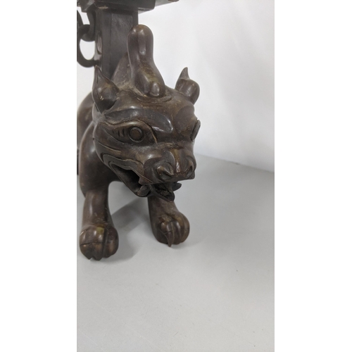 277 - A Chinese polished soapstone incense holder in the form of a foo dog with a pagoda mounted to its ba... 