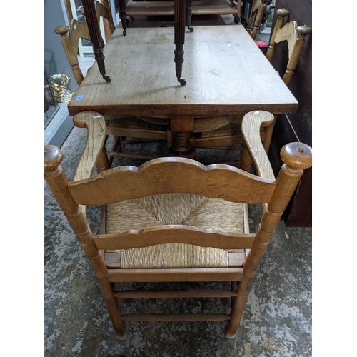 77 - An oak trestle end dining table, rectangular top supported on turned columns, united by square stret... 