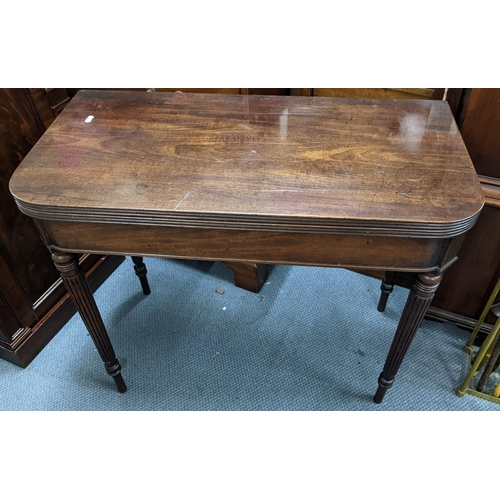 499 - An early 19th century Gillows style mahogany fold over tea table on four fluted tapering legs, 73cm ... 