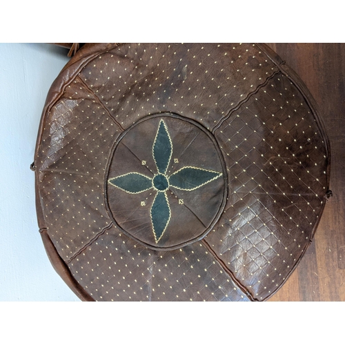 462 - Two pouffes, one circular and one square in brown leather, each decorated with a central flower
Loca... 