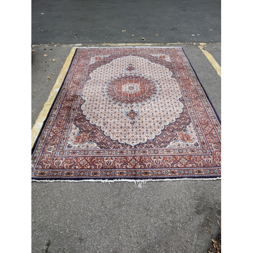 513 - A Persian Tabriz handwoven rug, allover floral pattern on a cream and blue ground, triple guard bord... 