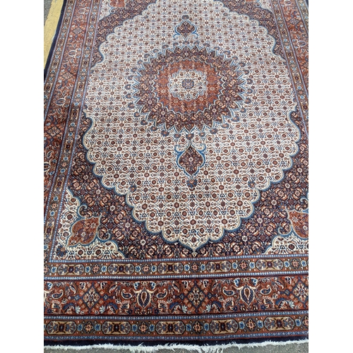 513 - A Persian Tabriz handwoven rug, allover floral pattern on a cream and blue ground, triple guard bord... 