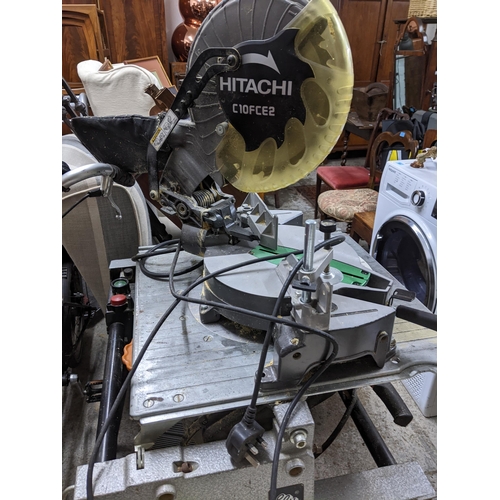 518 - A Hitachi C10FCE2 mitre saw, on an Elu work stand, along with a Record Power RPBS8 bandsaw Location:... 