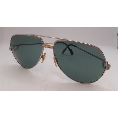 14 - Cartier- A pair of large aviator style sunglasses having green tinged lenses and 2 tone hardware, si... 