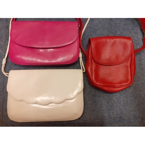 16 - Paloma Picasso and Bruno Magli-An unused red leather crossover/shoulder bag having gold tone hardwar... 