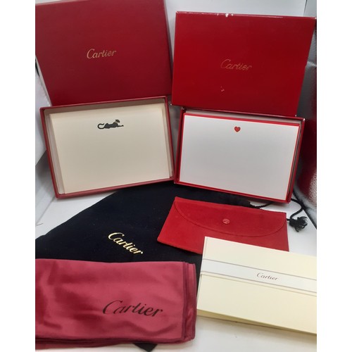 50A - Cartier- A small group of boxed stationary, a slip pochette case, a branded black drawstring belt du... 