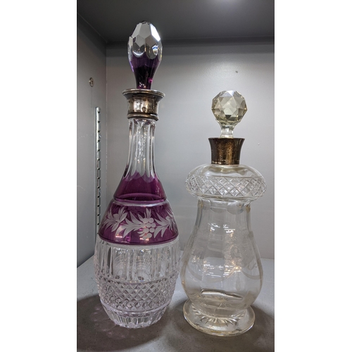 483 - Two silver coloured decanters to include a 1920's decanter with etched Adams style decoration and a ... 