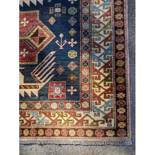 469 - An Afghan Kazak rug, handwoven, geometric designs on a blue ground, multiguard borders, tasselled en... 