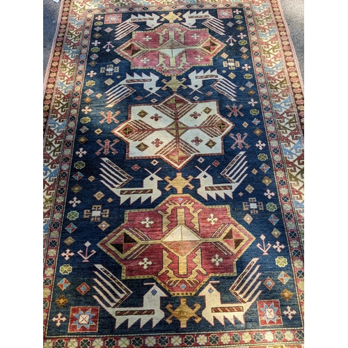 469 - An Afghan Kazak rug, handwoven, geometric designs on a blue ground, multiguard borders, tasselled en... 