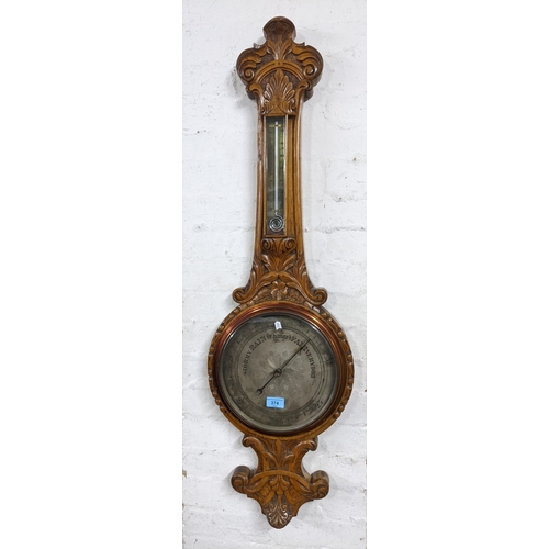 480 - A Victorian carved oak wheel barometer, silvered dial with engraved decoration to the centre, below ... 