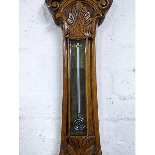 480 - A Victorian carved oak wheel barometer, silvered dial with engraved decoration to the centre, below ... 