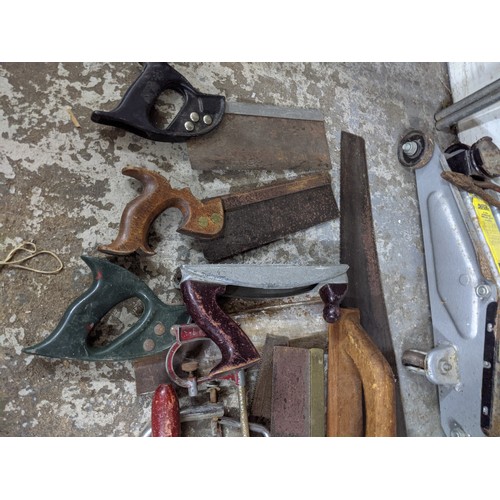 492 - A mixed lot of tools and gardening tools including a trolley jack, hobby fretsaw, spades, vintage sa... 