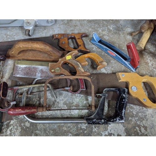 492 - A mixed lot of tools and gardening tools including a trolley jack, hobby fretsaw, spades, vintage sa... 