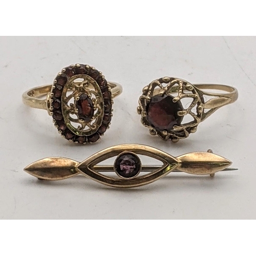 119 - A 9ct gold brooch set with an amethyst and two 9ct gold rings, each set with a garnet, total weight ... 