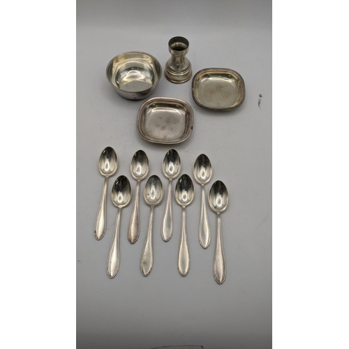 121 - Silver stamped 800 to include a set of eight teaspoons three pin dishes and a white metal pot, total... 