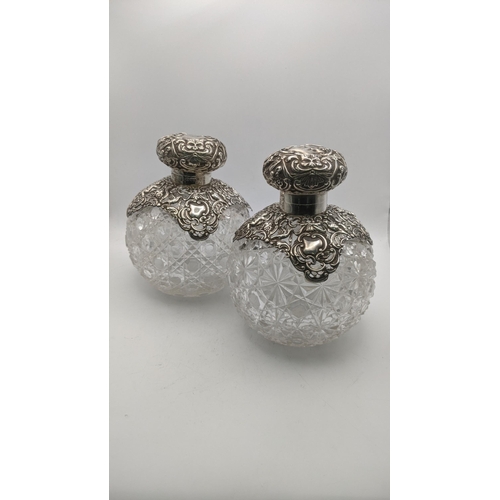 122 - A pair of silver top scent bottles in a floral design on crystal cut glass bottles A/F
Location: R2-... 