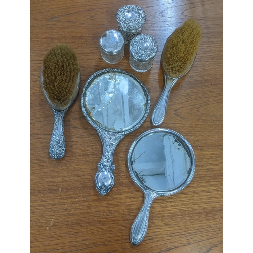 163 - Silver dressing table items to include two hand mirrors, three dressing table jars and two brushes
L... 