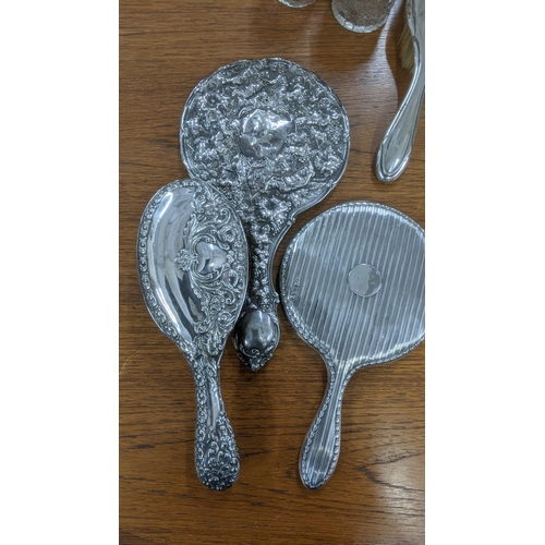 163 - Silver dressing table items to include two hand mirrors, three dressing table jars and two brushes
L... 