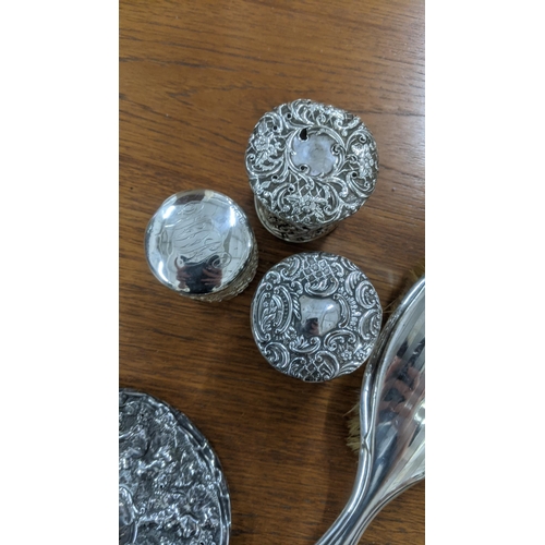 163 - Silver dressing table items to include two hand mirrors, three dressing table jars and two brushes
L... 