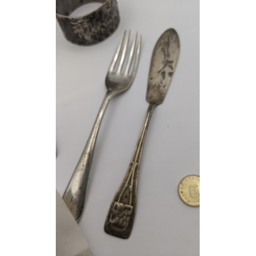 64 - Mixed silver to include a floral engraved napkin ring, three tea spoons and others total weight 110.... 