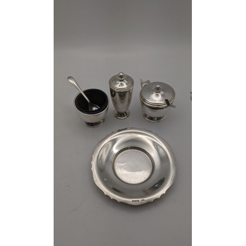 90 - A three piece silver condiment set with blue glass liners hallmarked Birmingham 1961 together with a... 