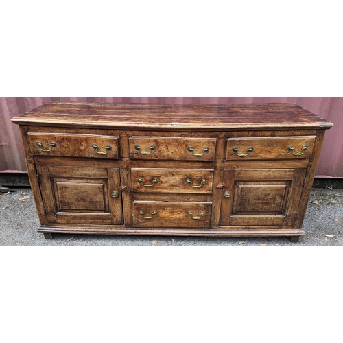 147 - An 18th century vernacular fruitwood sideboard, having three central drawers flanked by two further ... 