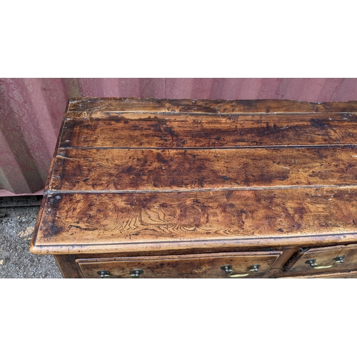 147 - An 18th century vernacular fruitwood sideboard, having three central drawers flanked by two further ... 