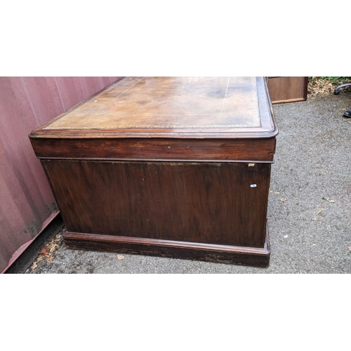 149 - A Victorian mahogany partners desk, having a leather topped scriber, above pedestals with eight frie... 