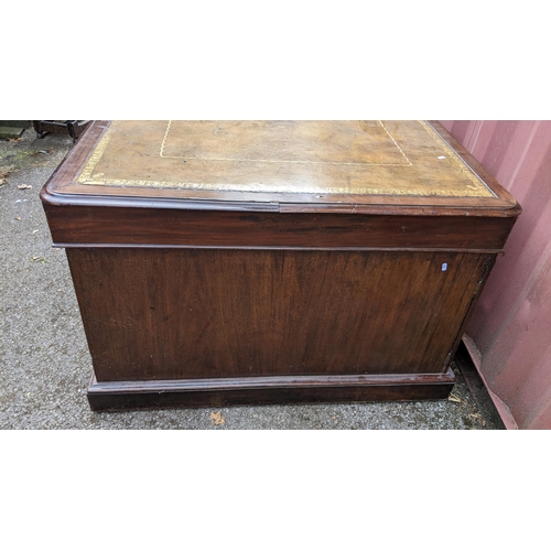 149 - A Victorian mahogany partners desk, having a leather topped scriber, above pedestals with eight frie... 