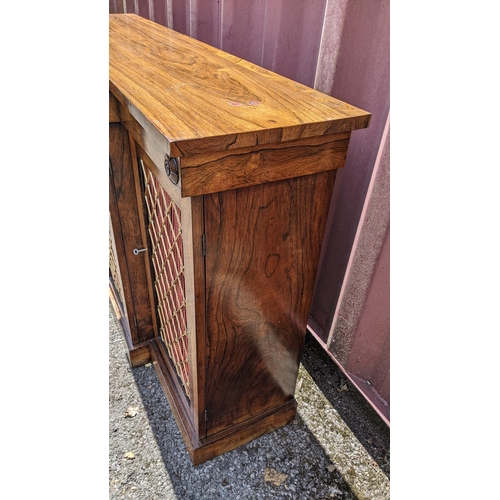 164 - A Regency rosewood breakfront sideboard, having four cupboard doors opening to reveal shelves, with ... 