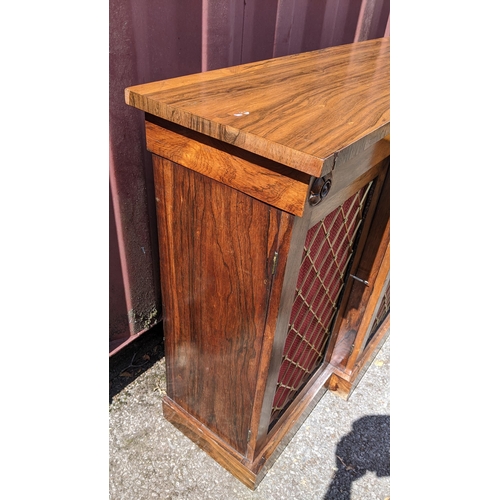 164 - A Regency rosewood breakfront sideboard, having four cupboard doors opening to reveal shelves, with ... 