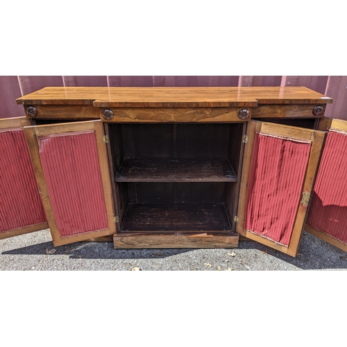 164 - A Regency rosewood breakfront sideboard, having four cupboard doors opening to reveal shelves, with ... 