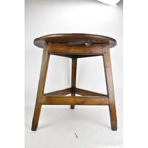 169 - An 18th century fruitwood topped vernacular cricket table, having a circular top, three splayed legs... 