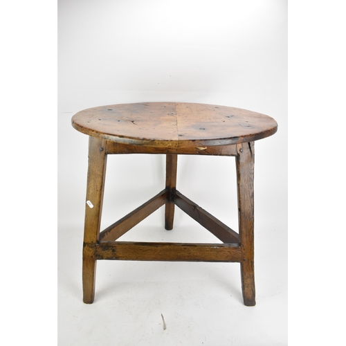 169 - An 18th century fruitwood topped vernacular cricket table, having a circular top, three splayed legs... 