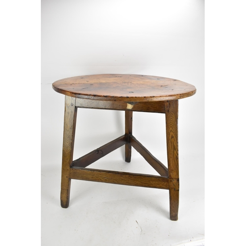 169 - An 18th century fruitwood topped vernacular cricket table, having a circular top, three splayed legs... 