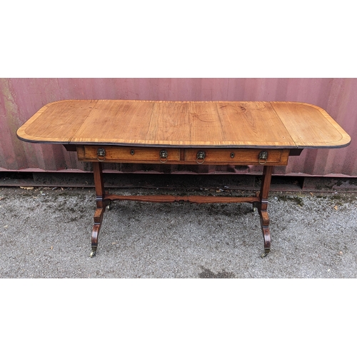 146 - A Regency mahogany sofa table, having a crossbanded rectangular top and two fall flaps, two frieze d... 