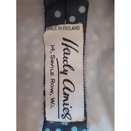 6 - Hardy Amies- A navy full length gown with white polka dot design throughout, having a double full le... 