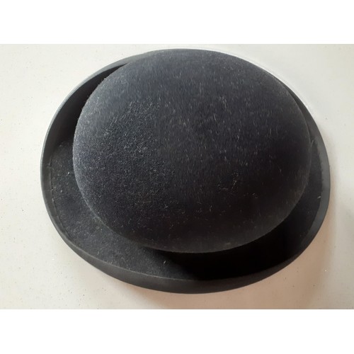 83 - A 'Best Manufacture Co' black bowler hat with interior leather band and red silk, internal circumfer... 