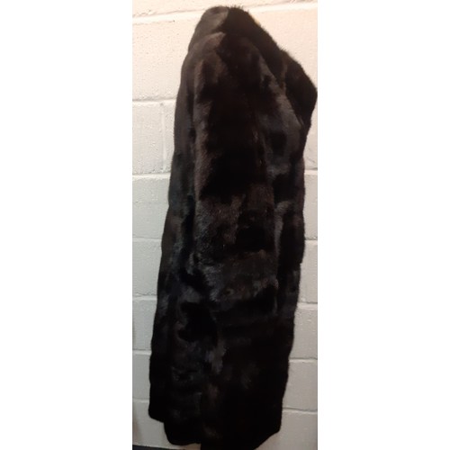 38 - A late 20th Century black glossy mink coat having a black satin lining with embroidered name and 2 s... 