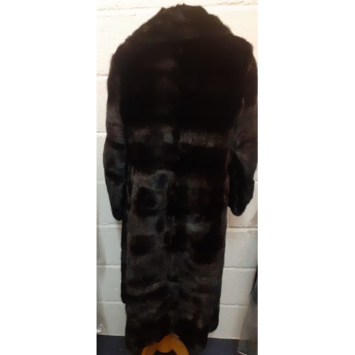 38 - A late 20th Century black glossy mink coat having a black satin lining with embroidered name and 2 s... 