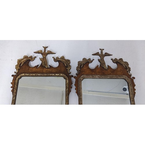 76 - A pair of 20th Century Chippendale style parcel-gilt, walnut mirrors surmounted by a bird foliage an... 