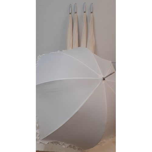 97 - Four off-white large umbrellas and one smaller white parasol, suitable for a wedding event. Location... 