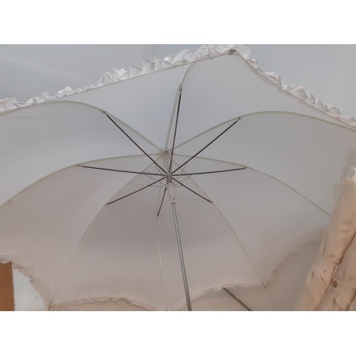 97 - Four off-white large umbrellas and one smaller white parasol, suitable for a wedding event. Location... 