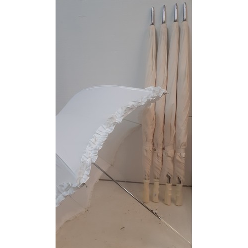 97 - Four off-white large umbrellas and one smaller white parasol, suitable for a wedding event. Location... 